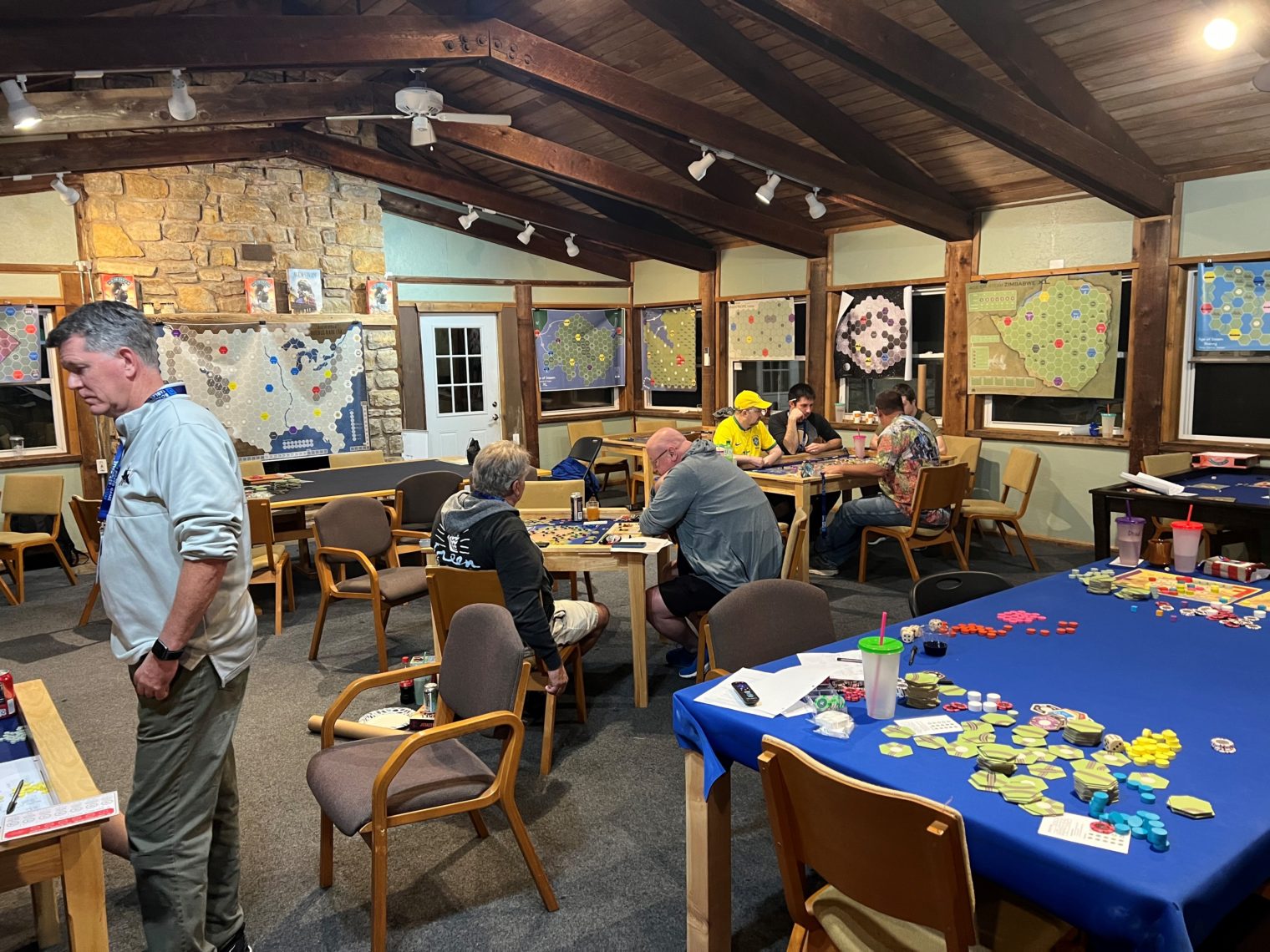 Scene from Age of SteamCon 2022, interior of large indoor area with many tables set up for games