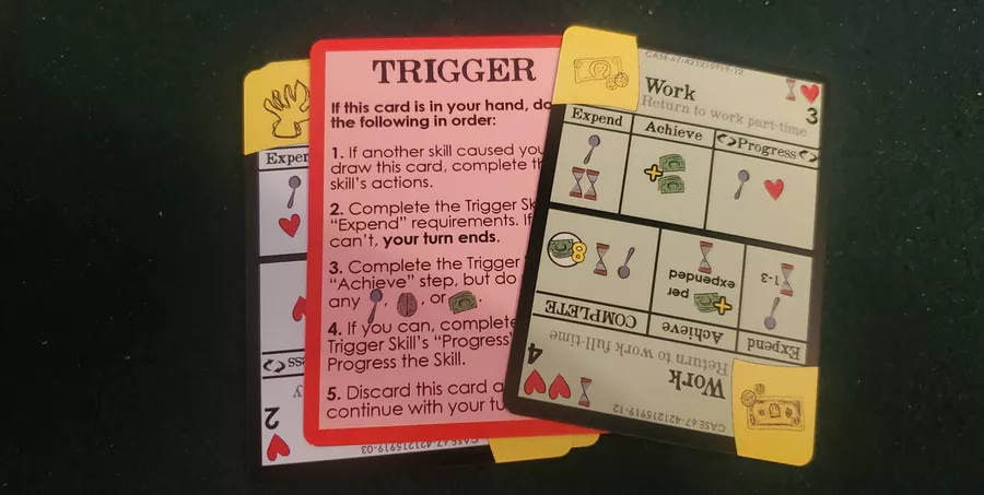 Three cards from Heading Forward game, "Trigger" card prominent in centre of picture.