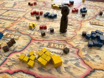 Close-up view of game of El Grande in progress showing King, cubes of different colours, and yellow Grande cube